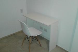 una silla blanca sentada bajo un escritorio en una habitación en Céntrico departamento en Godoy Cruz, Mendoza en Godoy Cruz