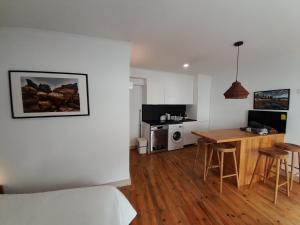 een keuken en een woonkamer met een tafel en stoelen bij Covil's Haus in Peniche