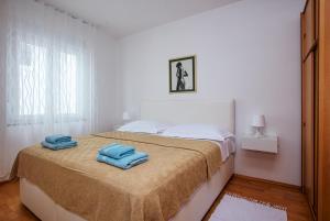 Apartments with parking space Pirovac, Sibenik - 15320 في بيروفاتش: غرفة نوم بها سرير عليه منشفتان