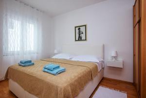 a bedroom with a bed with two towels on it at Apartments with a parking space Pirovac, Sibenik - 15320 in Pirovac