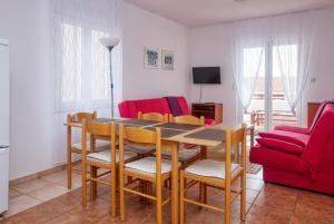 Apartments with parking space Pirovac, Sibenik - 15320 في بيروفاتش: طاولة طعام وكراسي في غرفة المعيشة