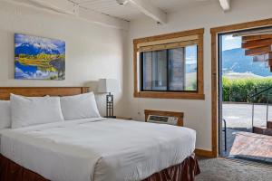 a bedroom with a bed and a large window at Elk Refuge Inn in Jackson