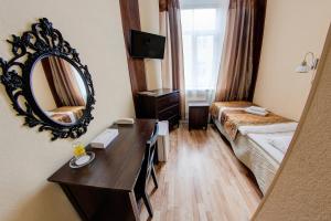 a hotel room with a mirror and a bed at Viktorija in Rīga