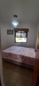 une chambre avec un lit et une fenêtre dans l'établissement Chalé Pé na Areia em Rio das Ostras, à Rio das Ostras