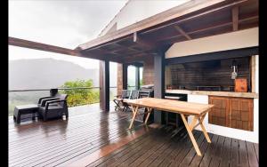 une terrasse en bois avec une table et des chaises. dans l'établissement Pousada RIO CALDO, à Rio Caldo