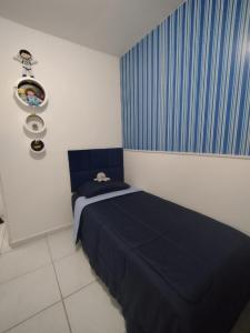 a bedroom with a bed and a blue curtain at AP Maria Farinha in Paulista