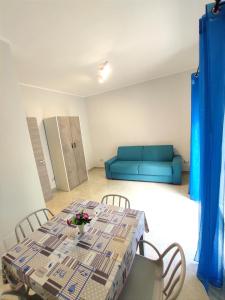 a living room with a table and a blue couch at Apartment NAPOLI MARADONA in Naples