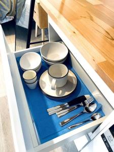 Modern Studio with Mountain View and Near Airport & CBD في Warrane: درج فيه صحون وادوات مطبخ +17 صورة