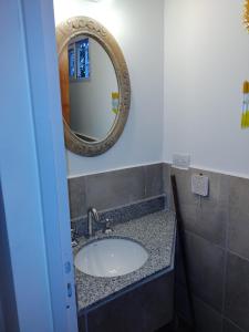 y baño con lavabo y espejo. en Casa en Cuesta Blanca dos dormitorios en Villa Icho Cruz
