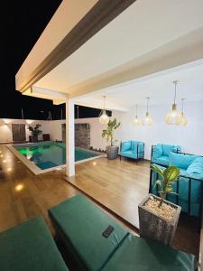 un salon avec un mobilier bleu et une piscine dans l'établissement VILLA NAYFAL, à Saly Portudal