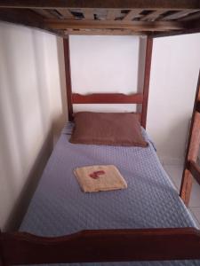 uma cama com uma estrutura de madeira e uma colcha azul em Apart 2 suites Pelinca em Campos dos Goytacazes