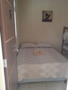 um pequeno quarto com uma cama e uma cadeira em Apart 2 suites Pelinca em Campos dos Goytacazes