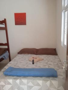 Una cama en una habitación con una manta azul. en Apart 2 suites Pelinca en Campos dos Goytacazes