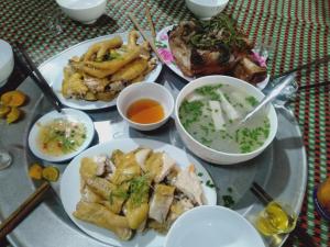 a table with plates of food and bowls of soup at Homestay Tuấn Nghĩa - Hang Phượng Hoàng - Võ Nhai in Hoan Chung