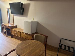 um quarto com uma mesa, um frigorífico e uma televisão em Plaza Inn Motel - Los Angeles area em Rosemead