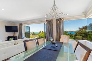 una sala de estar con una mesa de cristal con un pájaro. en Tui Lookout - Spa Pool & Lake Views, en Taupo
