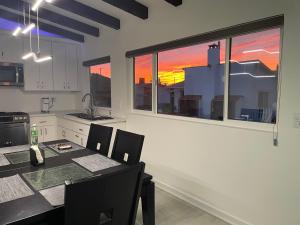 eine Küche mit Tisch und Stühlen und zwei Fenstern in der Unterkunft Ocean View, Private, Quiet in Chapultepec