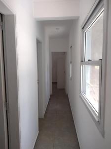 un pasillo vacío con una ventana en una habitación blanca en Juansa del mar en La Lucila del Mar