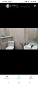 een foto van een badkamer met een toilet en een wastafel bij Riki Guesthouse Syari'ah in Jepara
