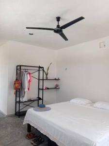 um quarto com uma cama e uma ventoinha de tecto em Casa Calandria em Chicxulub