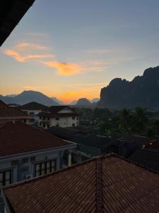 a view of the sunset from the roofs of buildings at Jasmine Vangvieng Hotel in Vang Vieng