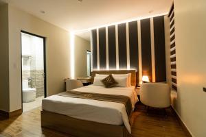 a bedroom with a large bed and a bathroom at The One Hotel in Hai Phong