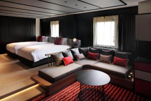 a hotel room with a bed and a couch and a bed at Cross Hotel Osaka in Osaka