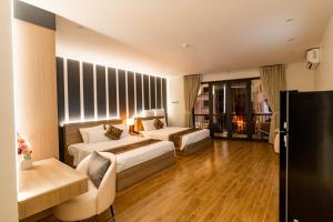 a hotel room with two beds and a couch at The One Hotel in Hai Phong