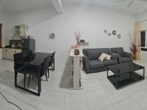 a living room with a couch and a table and chairs at Full Moon Apartment (月满公寓）网红 airbnb in Kuah