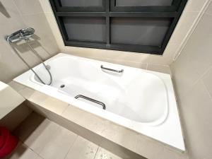 a white bath tub in a bathroom with a window at KL Gateway Residency in Kuala Lumpur