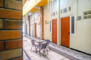 a patio with a table and chairs in a building at RedDoorz near Puri Anjasmoro Area Semarang in Semarang