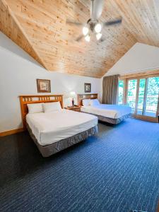 a bedroom with two beds and a wooden ceiling at Ruttger's Bay Lake Resort in Deerwood