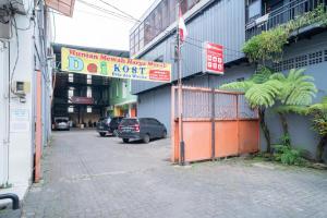 a street with cars parked next to a building at RedDoorz near Flyover Arjosari Malang in Malang