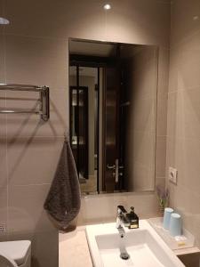 uma casa de banho com um lavatório e um espelho em Luxury Puri Mansion Apartment Kembangan em Jakarta