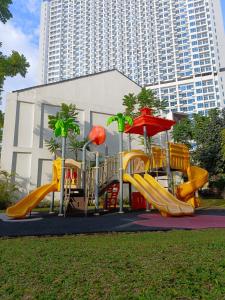 um parque infantil com escorrega num parque em Luxury Puri Mansion Apartment Kembangan em Jakarta