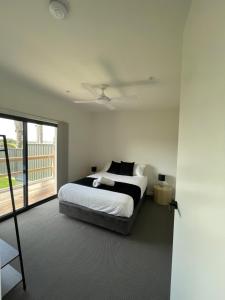 Habitación blanca con cama y balcón. en Inverloch Motel, en Inverloch