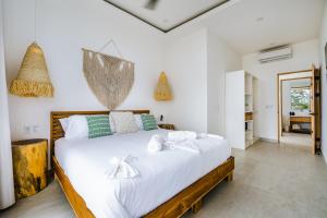 a bedroom with a large white bed with towels on it at The mVilla with Exclusive Beach Club Access in Tamarindo
