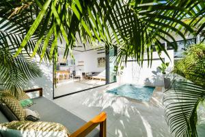 a room with a swimming pool in a house with palm trees at The mVilla with Exclusive Beach Club Access in Tamarindo