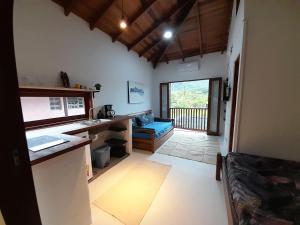 a room with a kitchen and a living room at Hakuna Studios Barra do Sahy in Barra do Sahy