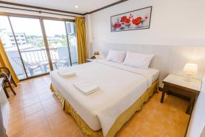 um quarto com uma cama grande e uma varanda em South Siam Hotel em Cidade Phuket