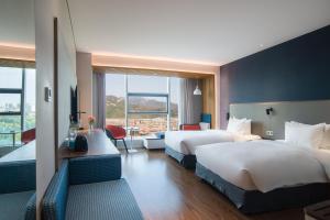 een hotelkamer met 2 bedden en een balkon bij Holiday Inn Express Taian City Center, an IHG Hotel in Tai'an