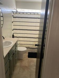 a bathroom with a white toilet and a sink at 3BR 2min from I-40,near DT, 21 min Palo Duro in Amarillo