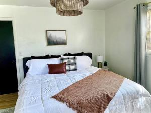 um quarto com uma grande cama branca com almofadas vermelhas em 3BR 2min from I-40,near DT, 21 min Palo Duro em Amarillo