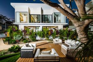 dom z białymi meblami i drzewem w obiekcie Tamarindo Luxury with Beach Club Access w mieście Tamarindo
