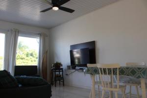 een woonkamer met een plafondventilator en een televisie bij Apartamento em Torres in Torres