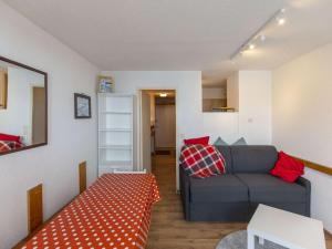 een woonkamer met een bank en een tafel bij Studio La Mongie, 1 pièce, 5 personnes - FR-1-404-343 in Bagnères-de-Bigorre