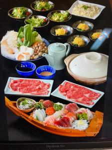 een tafel met veel verschillende borden eten erop bij 丸源旅館 無料朝食 全館wifi 準天然温泉 in Iwata