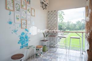 um quarto com paredes brancas, uma janela e uma mesa em Twin House near UII Yogyakarta Mitra RedDoorz em Yogyakarta