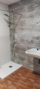 baño con lavabo blanco y suelo de madera en Lodge El Muelle De Arinaga, en Arinaga