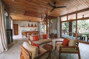 a living room with wooden ceilings and a dining room at Diamond Beach Villas in Nusa Penida